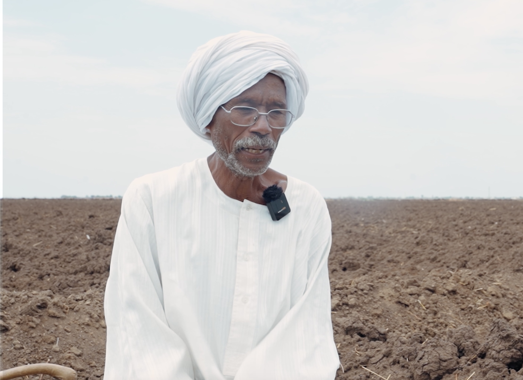Mudathir Yousif shares his story during a field visit. 15 July 2025. Roweina village, South Al Jazirah locality, Al Jazirah State, Sudan. Photo credit: FAO/Mohamed Ahmed.