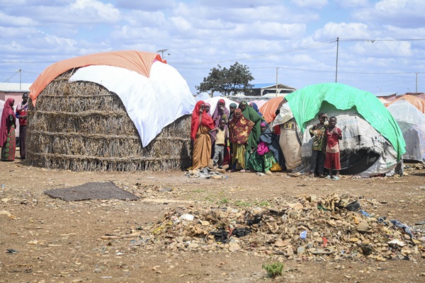 Women and children stand outside their makeshift shelters within Raama Cadeey Internally Displaced Persons (IDPs) camp in Baidoa, Somalia.