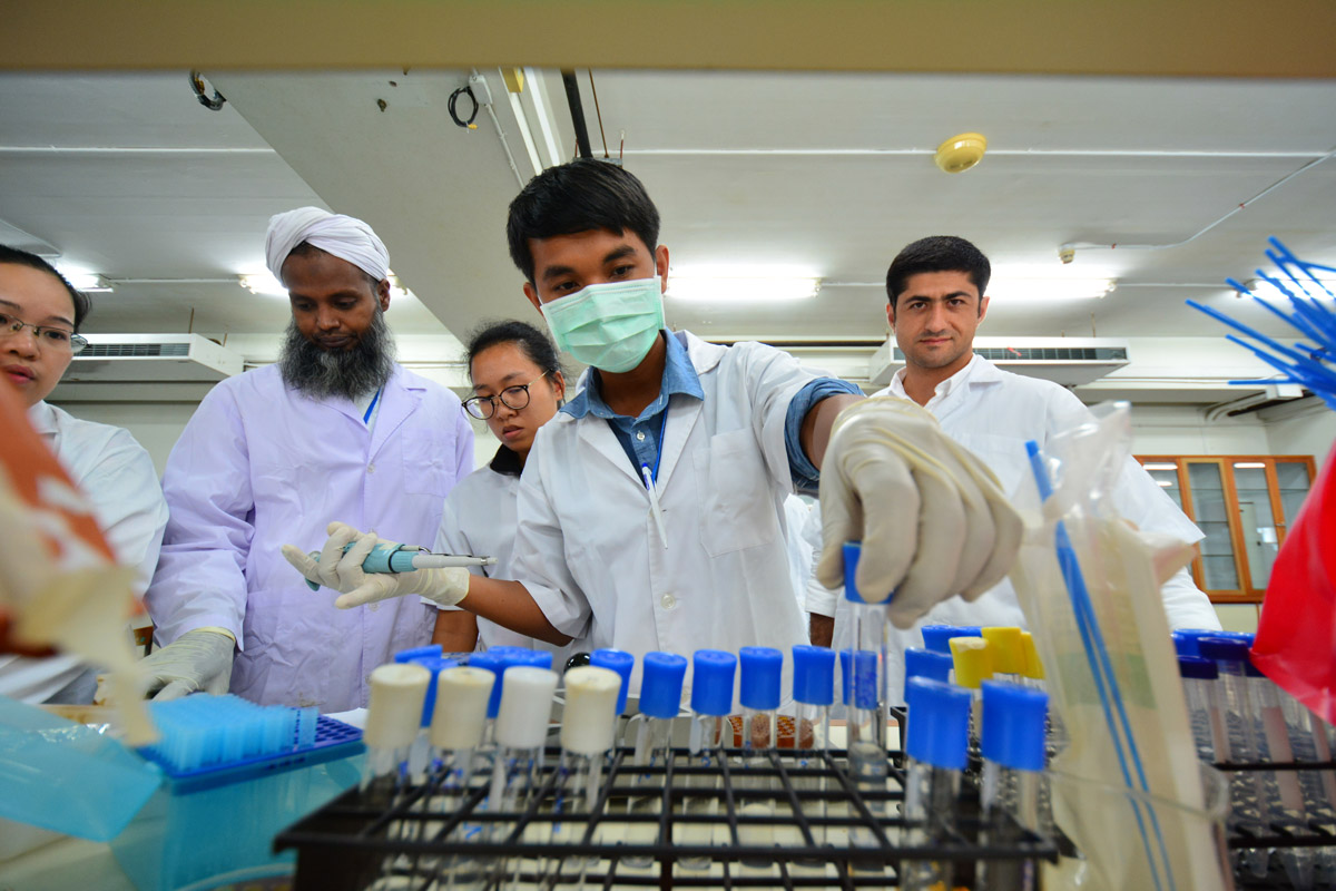 Lab staff putting a beaker in container