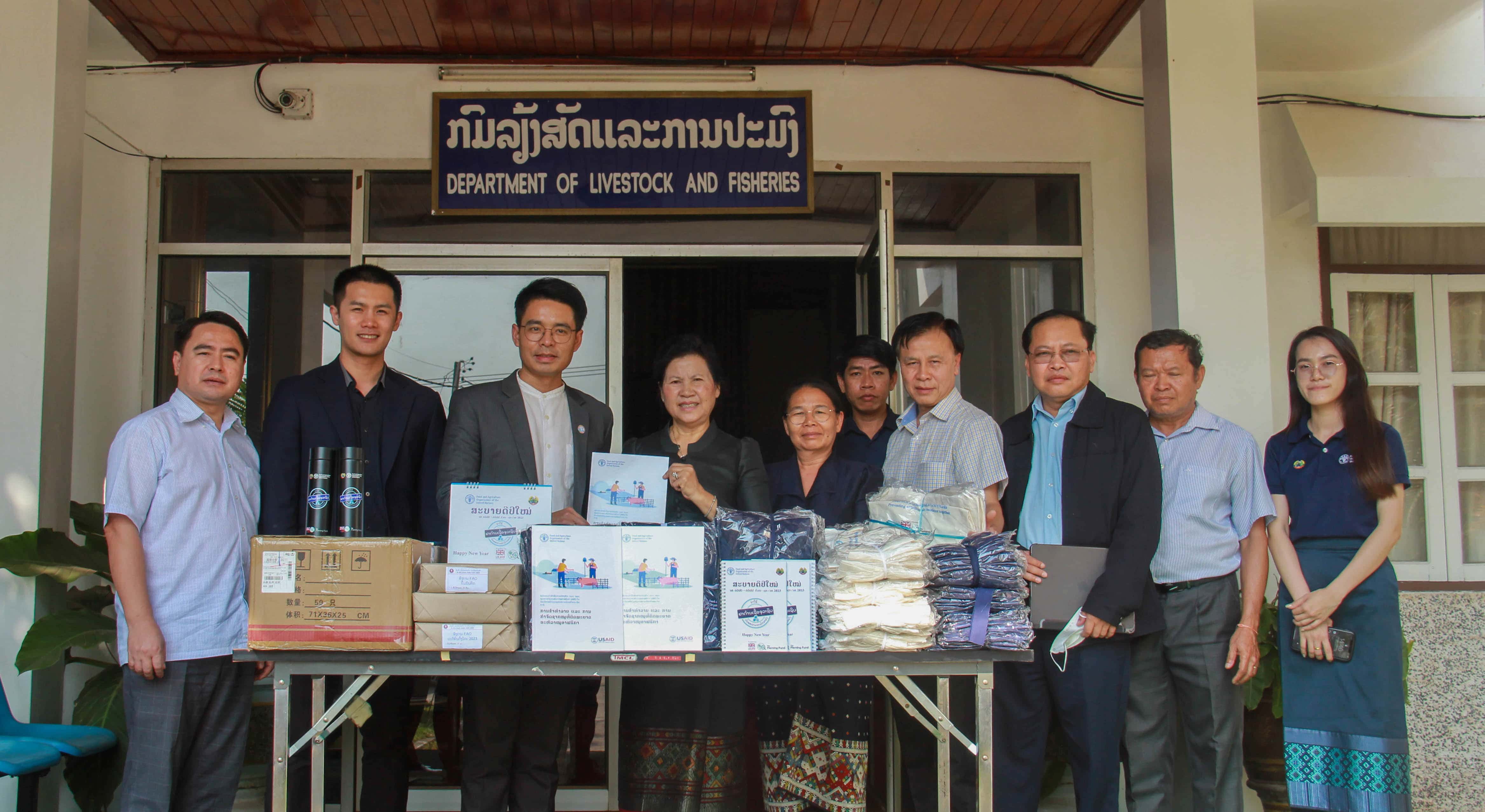 FAO Lao PDR and government staff in front of promotional materials related to AMR and ASF