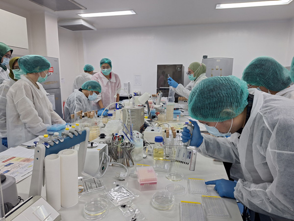People in lab gown working in a lab