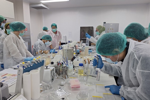 People in lab gown working in a lab