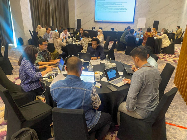 Group of people meeting seated in round tables.