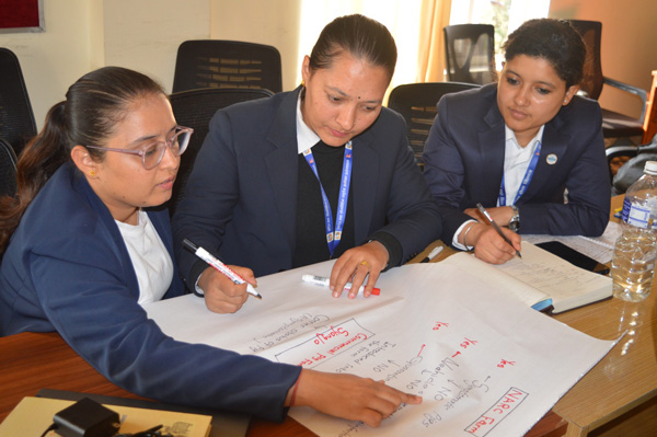 Three women discussing while working  on a flip chart paper