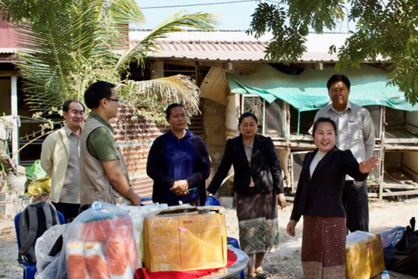 A lady farmer points to a direction in a meeting with a technical officers and other farmers.