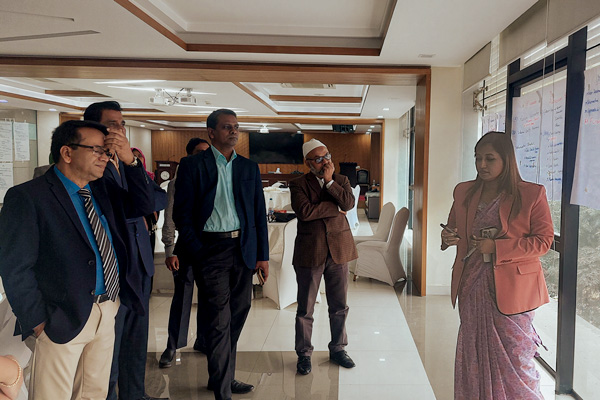 A woman leads a discussion among men during a workshop.